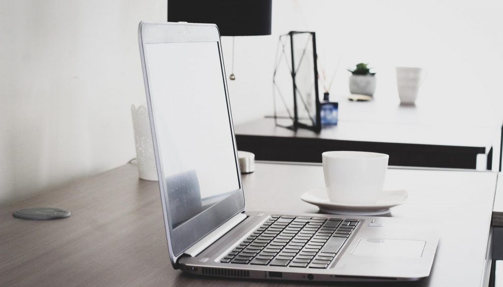 Notebook e xícara de café em ambiente profissional